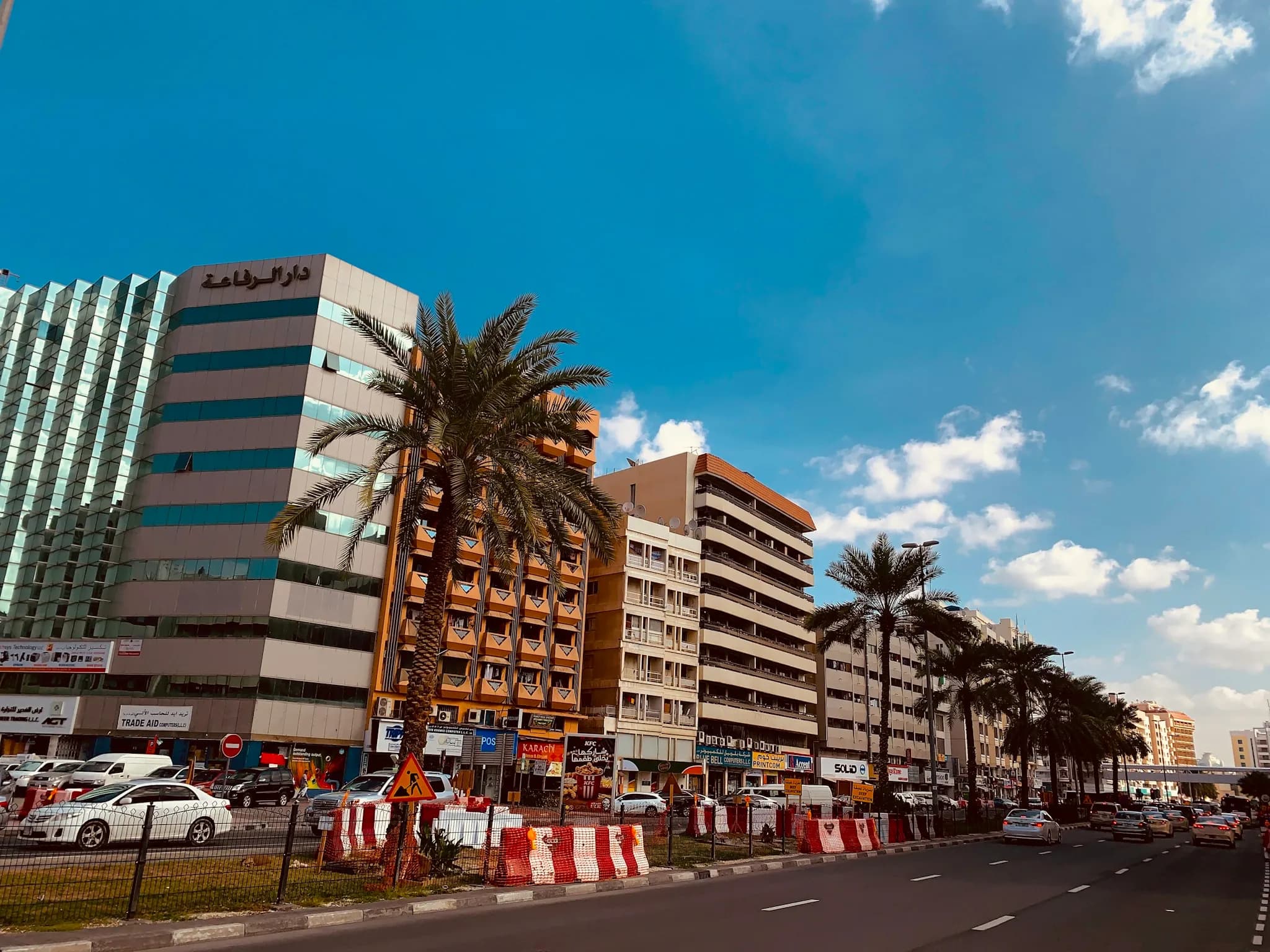 A palm-lined street of office buildings in the Gulf