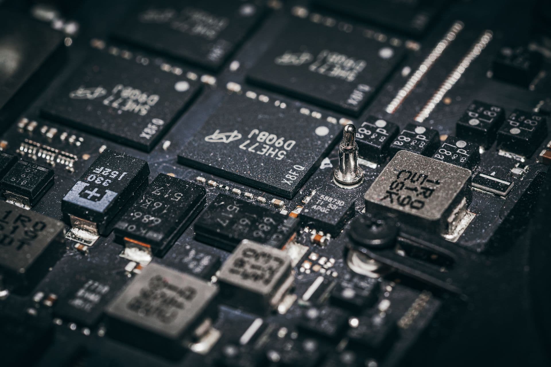 Macro close-up of microchips and components on a dark circuit board