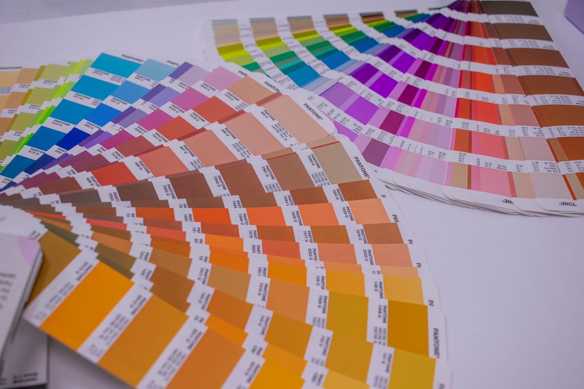 Colour swatch fan books spread open in a rainbow of shades