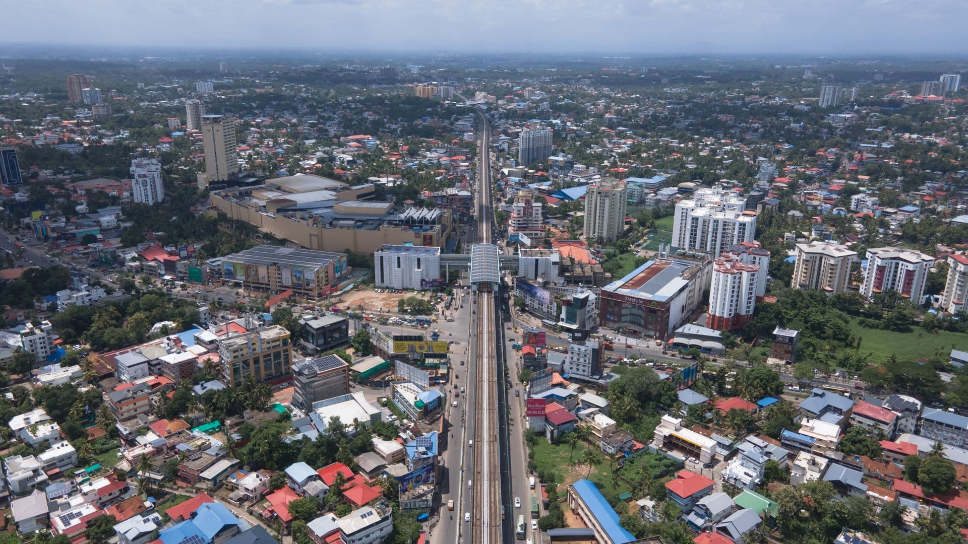 Aerial view of Kochi with apartment towers, rooftops and an elevated rail line