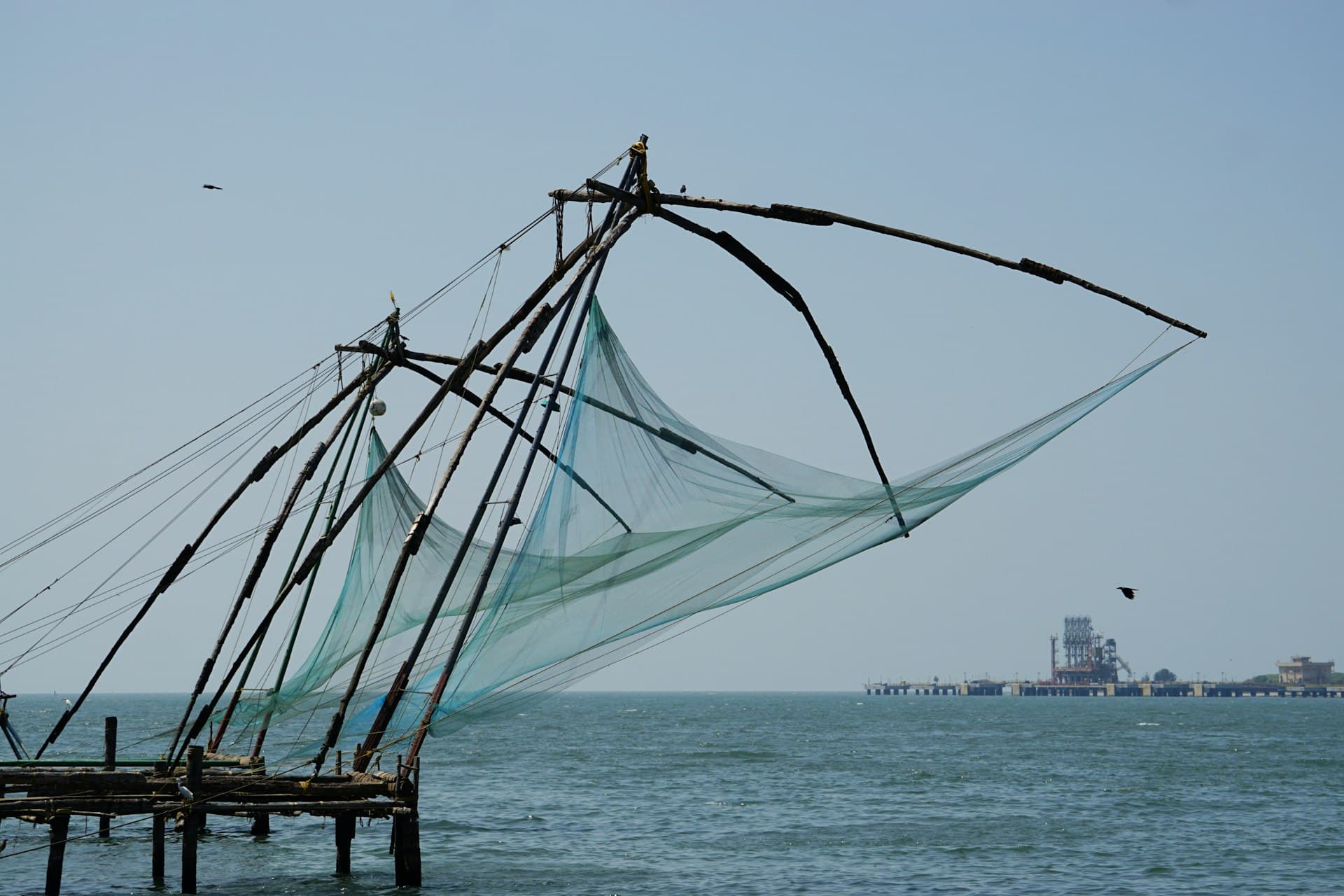 Traditional Chinese fishing nets on wooden stilts reaching out over the sea in Kochi, Kerala