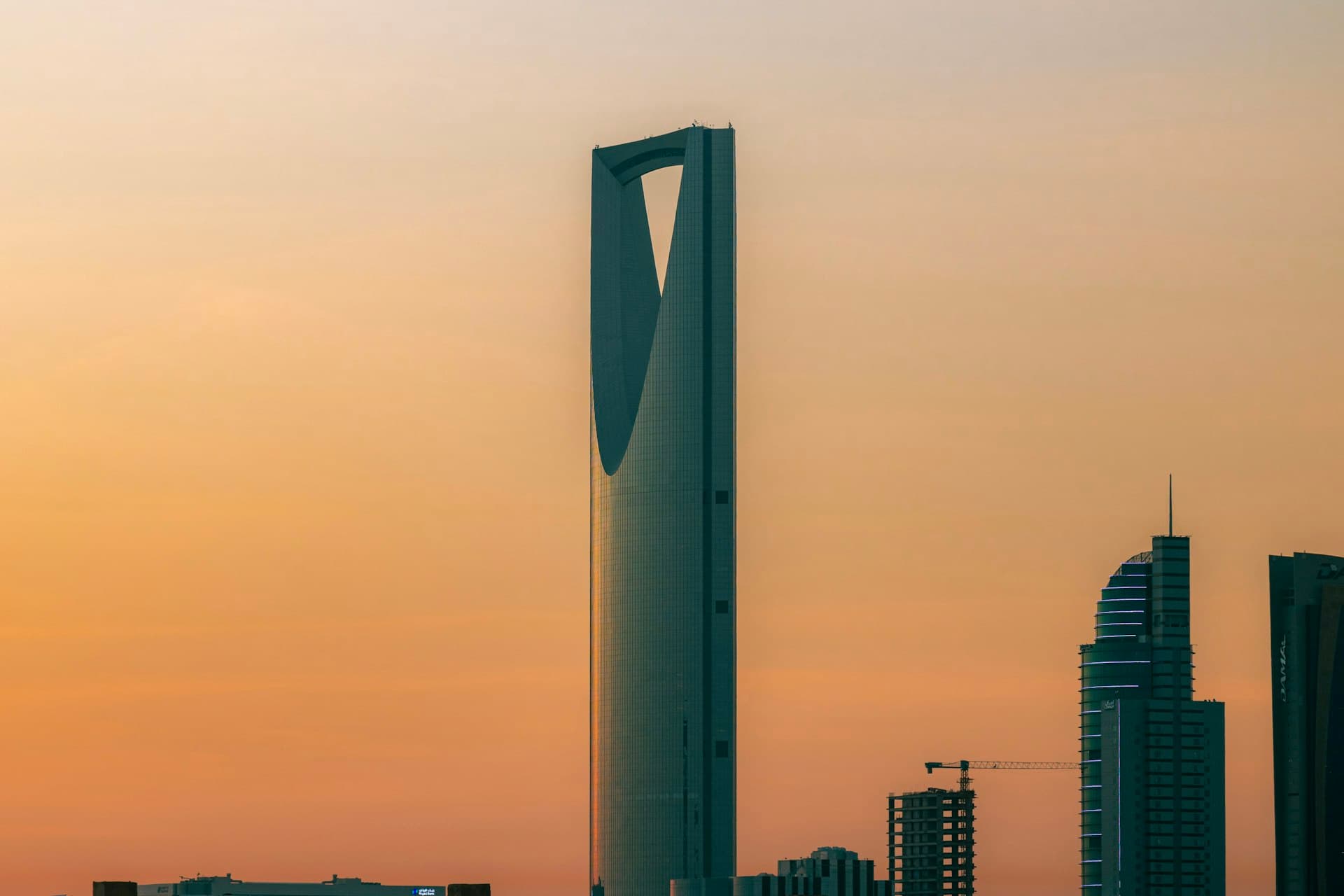 Kingdom Centre tower rising against a warm orange evening sky in Riyadh, Saudi Arabia