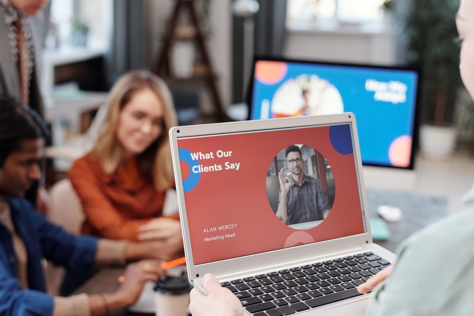 Team gathered around a laptop showing a website testimonials section in a bright office